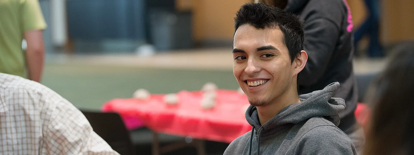 Male student looking happy socializing with his peers.