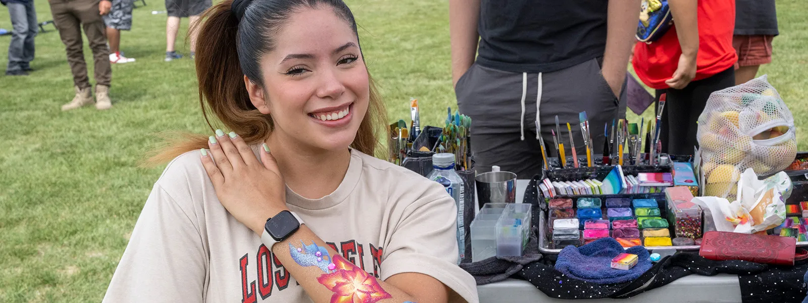 Estudiante con diseño floral de pintura corporal en el brazo