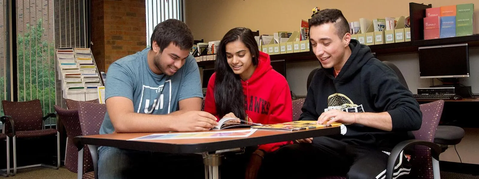 Students working at a desk in the academic advising office.