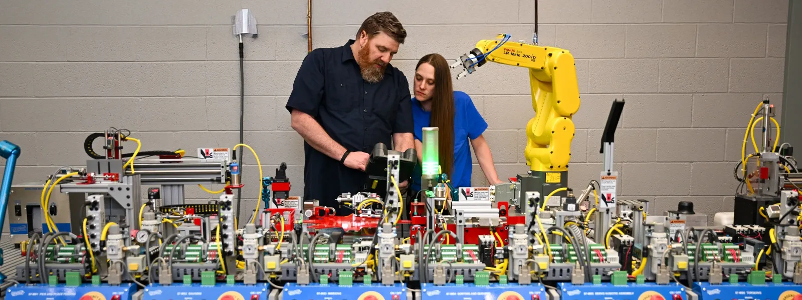 A professor helping a robotics student