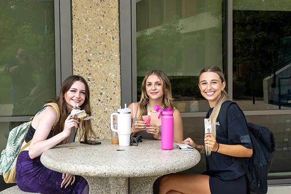 three students siting around a table