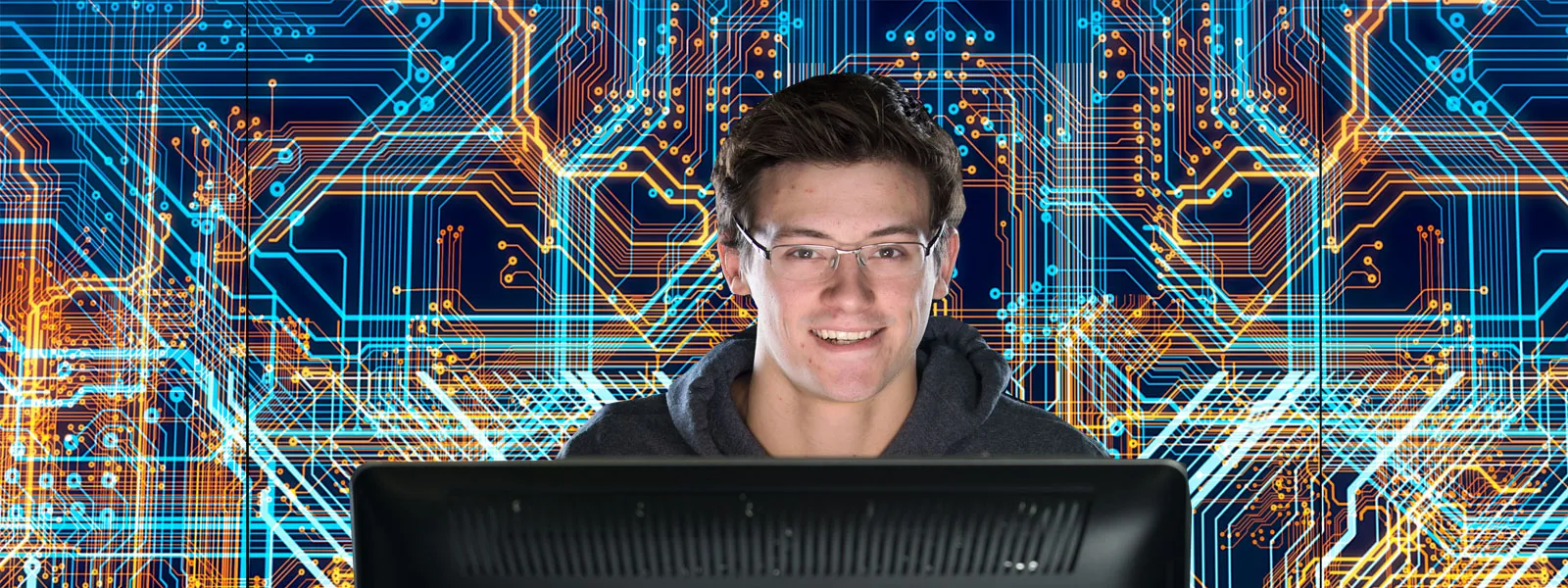Student wears glasses and works on a computer in the digital lab at ECC Spartan Drive Campus.