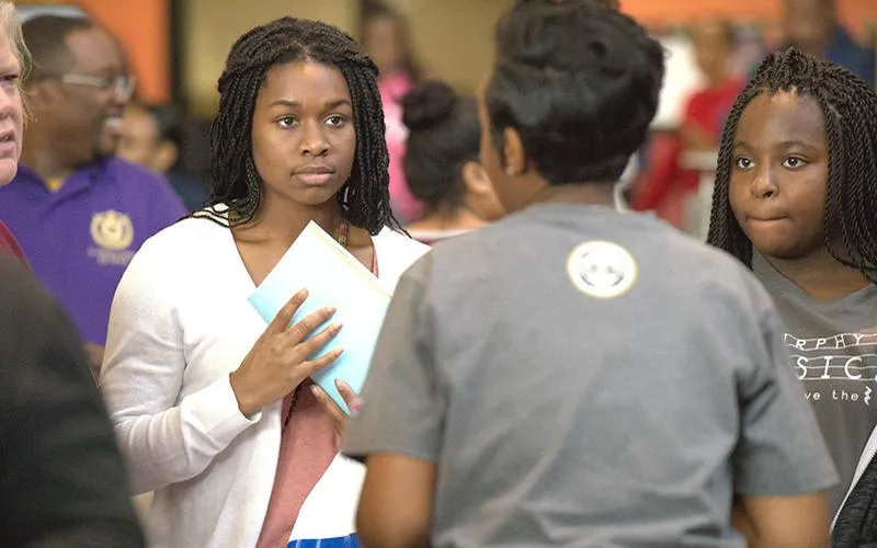 Two African-American students speak to an HBCU representative during last year's fair