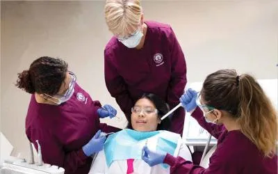 Dental assisting students work with a patient