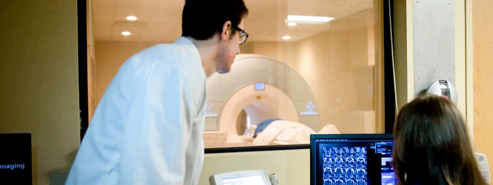 Imaging technicians observe an MRI procedure