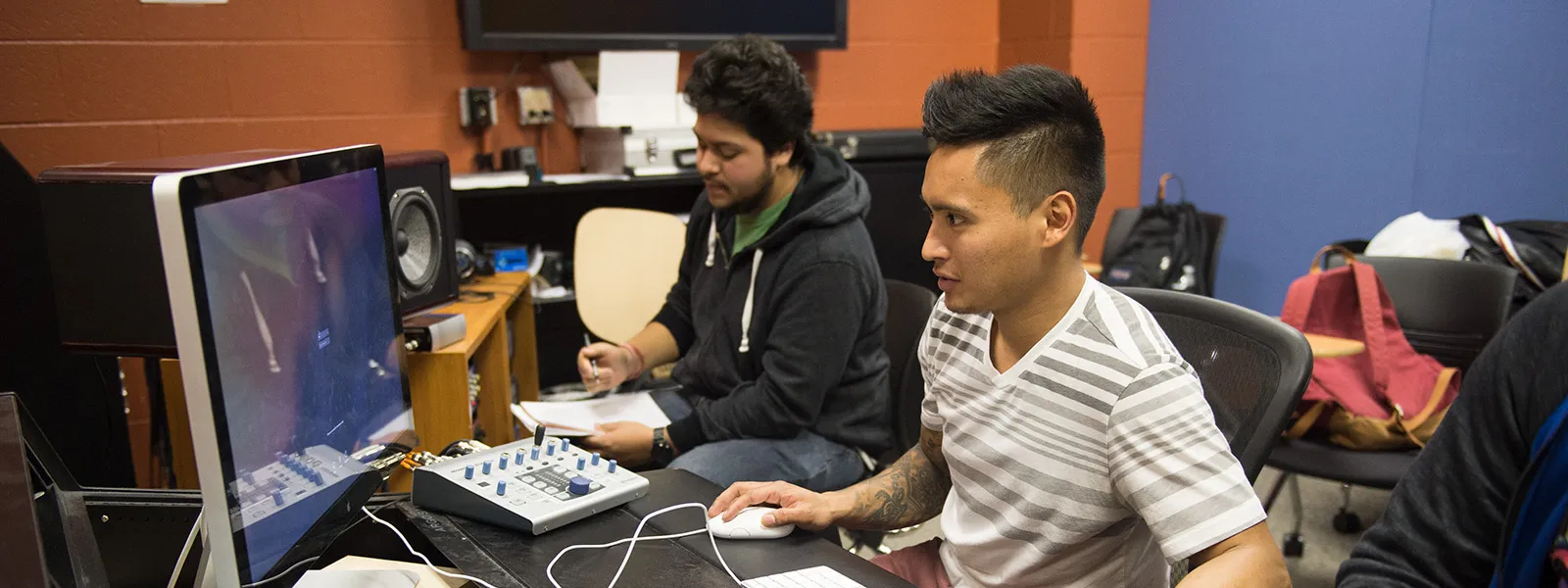 Students working on computer and music instruments