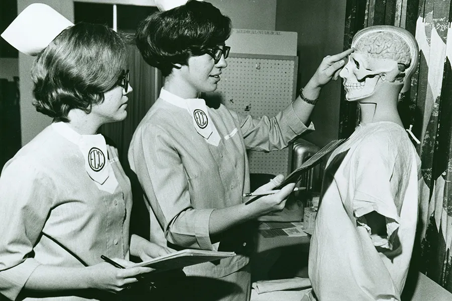 Nursing students attending to a mannequin