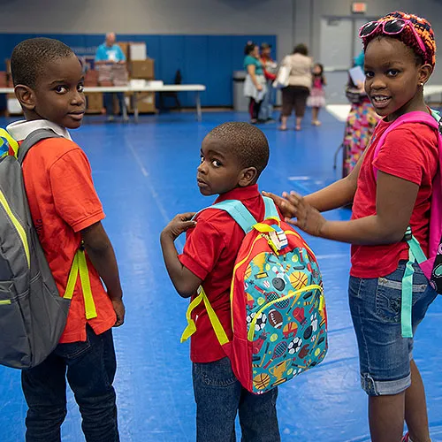 Children posing with their new backpacks.