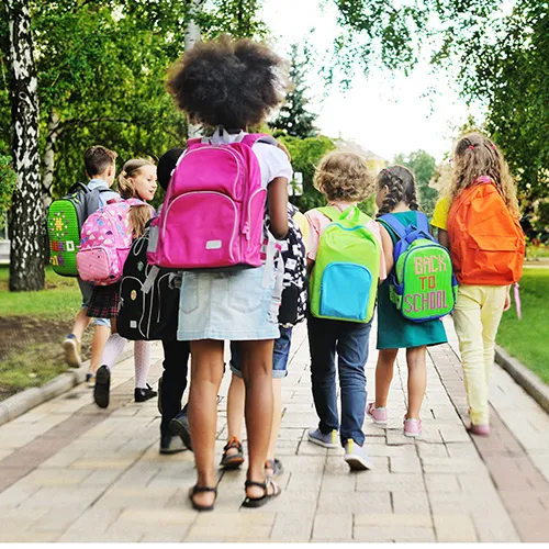 Students walking to school with backpacks.