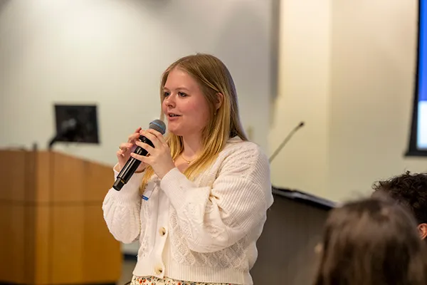 Scholar speaking into a microphone