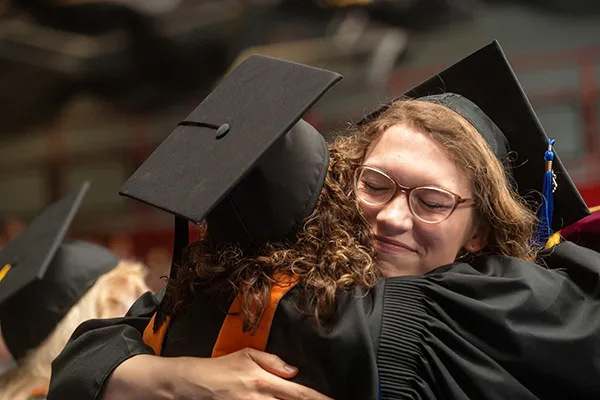 Two students hugging at the convocation