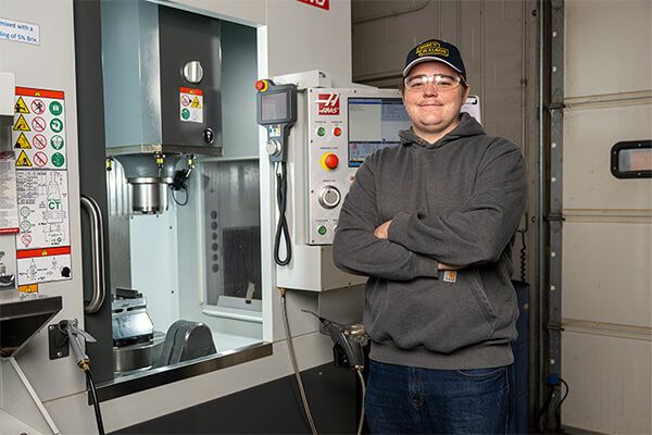 Career tech student smiling with arms crossed.